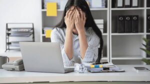 Ilustración de oficina con ambiente tenso, empleados estresados y concepto visual de incivility laboral afectando productividad