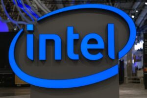 Joven con computadora y gráfico bursátil descendente tras caída en acciones de Intel