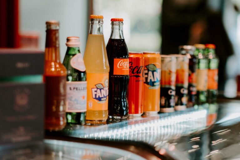 Varias botellas de refresco con un gráfico de aumento que refleja el nuevo impuesto sobre refrescos sin azúcar en México