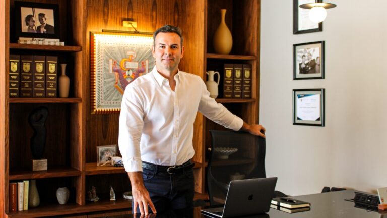 Omar Anitua Valdovinos frente a un puerto mexicano moderno con buques y grúas que simbolizan inversión y sostenibilidad marítima.