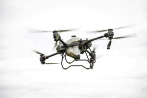 Dron agrícola DJI Agras T100 volando sobre campo español con alta precisión tecnológica