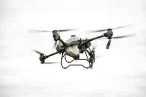 Dron agrícola DJI Agras T100 volando sobre campo español con alta precisión tecnológica