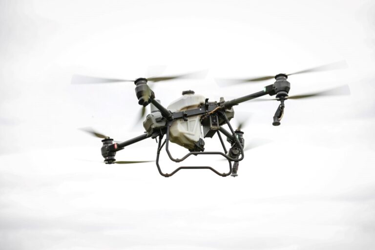 Dron agrícola DJI Agras T100 volando sobre campo español con alta precisión tecnológica