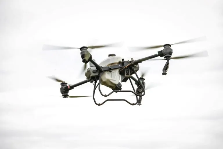 Dron agrícola DJI Agras T100 volando sobre campo español con alta precisión tecnológica