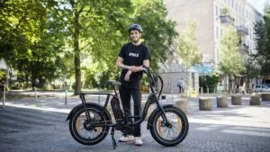 Empleados de Rad Power Bikes en Seattle junto a bicicletas eléctricas en una planta de ensamblaje.