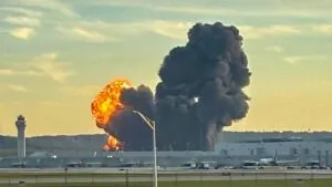 Avión de carga MD-11 de UPS estacionado en pista con personal de seguridad.