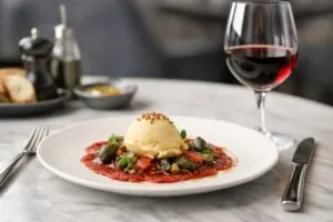 Helado gourmet servido en plato salado de alta cocina como parte de un maridaje con vino