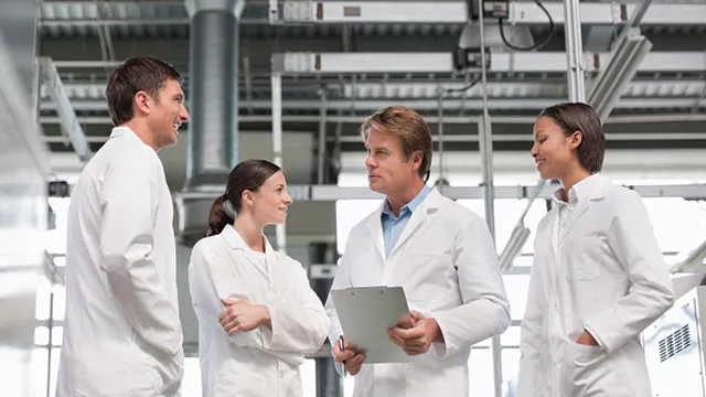 Investigadores en laboratorio analizando métricas y planificación estratégica como parte de la gestión de laboratorios moderna en 2026