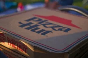Fachada Pizza Hut con logo rojo reflejando noticia sobre cierre de 250 locales en Estados Unidos