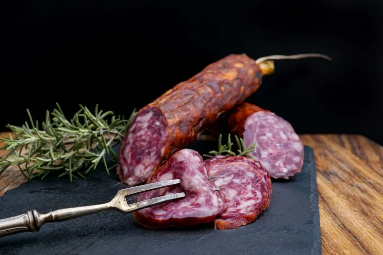 Estantería con productos cárnicos latinos incluyendo salami dominicano bajo estándares europeos
