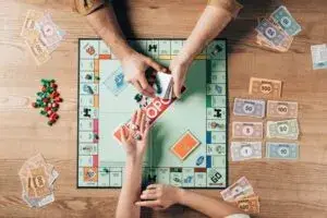 Grupo de personas jugando juegos de mesa modernos alrededor de una mesa con fichas, cartas y tableros.