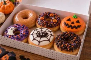 Donas glaseadas y decoradas para Halloween que representan la estrategia de productos de temporada de Krispy Kreme.