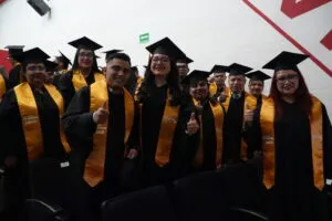 Colaboradores de Grupo Elektra con togas y estolas amarillas durante la ceremonia de certificación LÍDER 21.