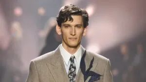Tres trajes elegantes para hombre exhibidos en una boutique, representando las diferentes marcas y estilos de sastrería masculina.