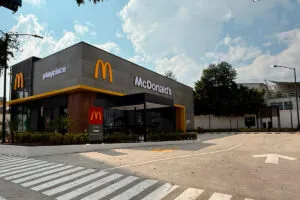 Una sucursal moderna de McDonald’s con clientes utilizando kioscos digitales.
